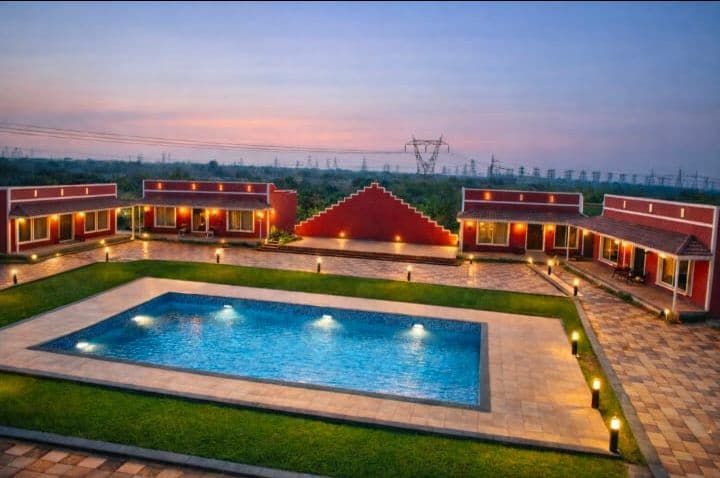 Leela Resort pool at dusk with cottages